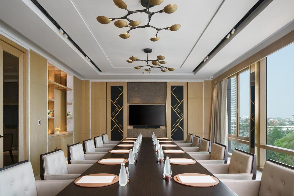 A formal meeting room with a long conference table and city-facing windows.