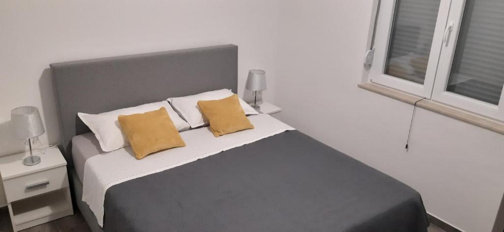 una camera con un letto con due cuscini gialli di Apartmani Antea a Starigrad-Paklenica (Ortopula)