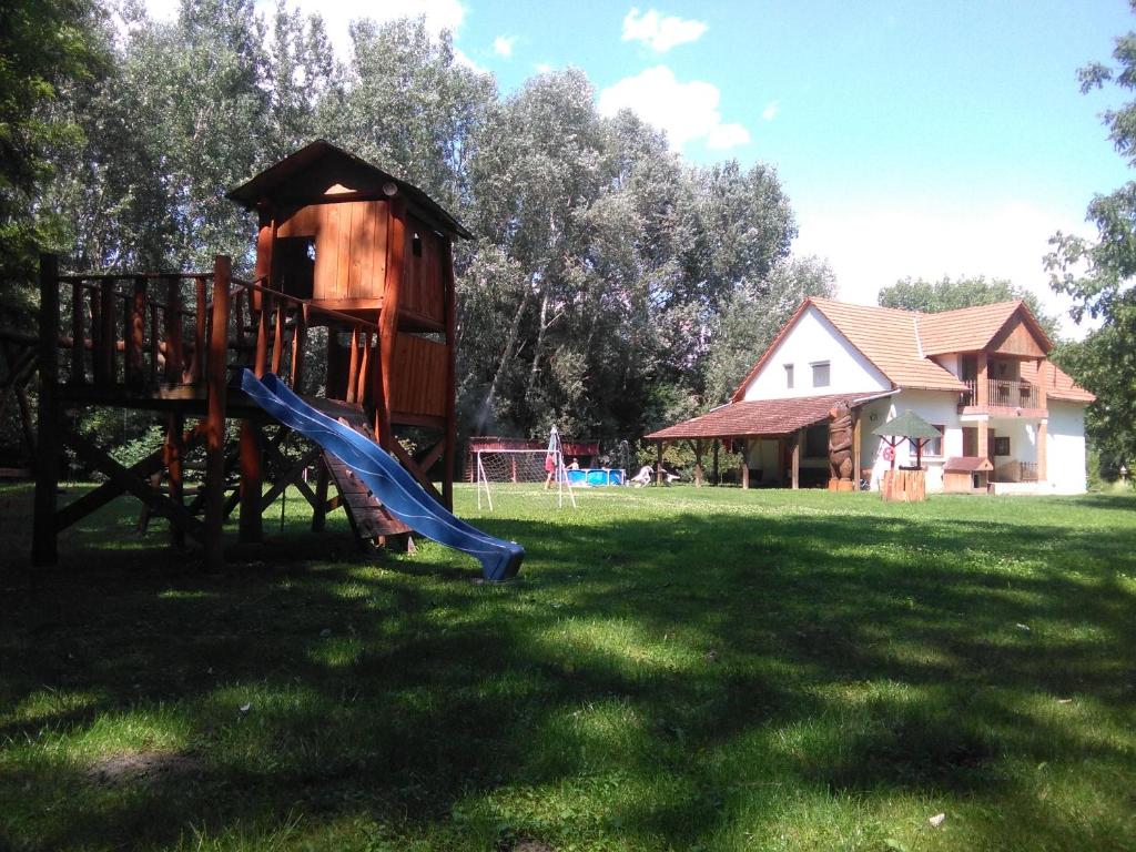 un parque infantil con un tobogán en el césped en Maci Vendégház en Békéscsaba