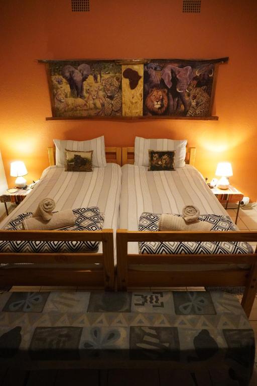 2 łóżka pojedyncze siedzące obok siebie w pokoju w obiekcie Okahandja Guesthouse w mieście Okahandja