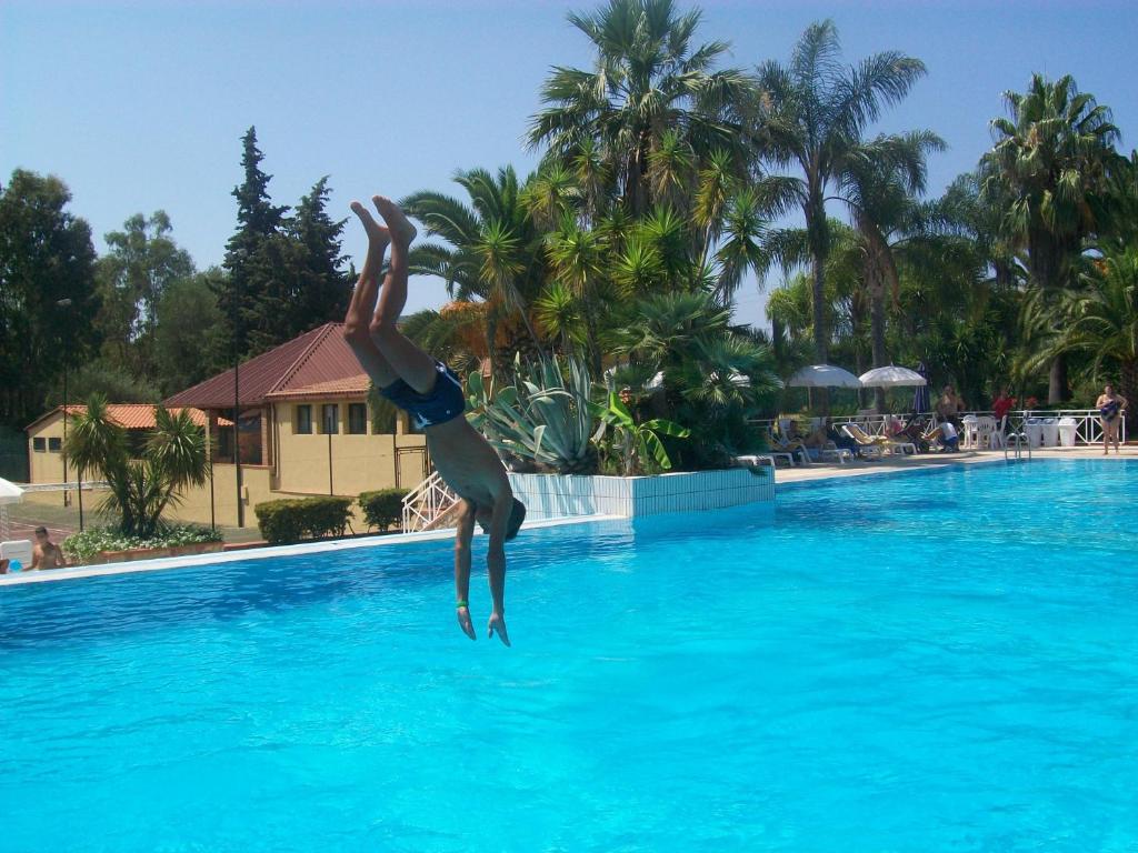 a person jumping into a swimming pool at Residence Trivento in Palinuro