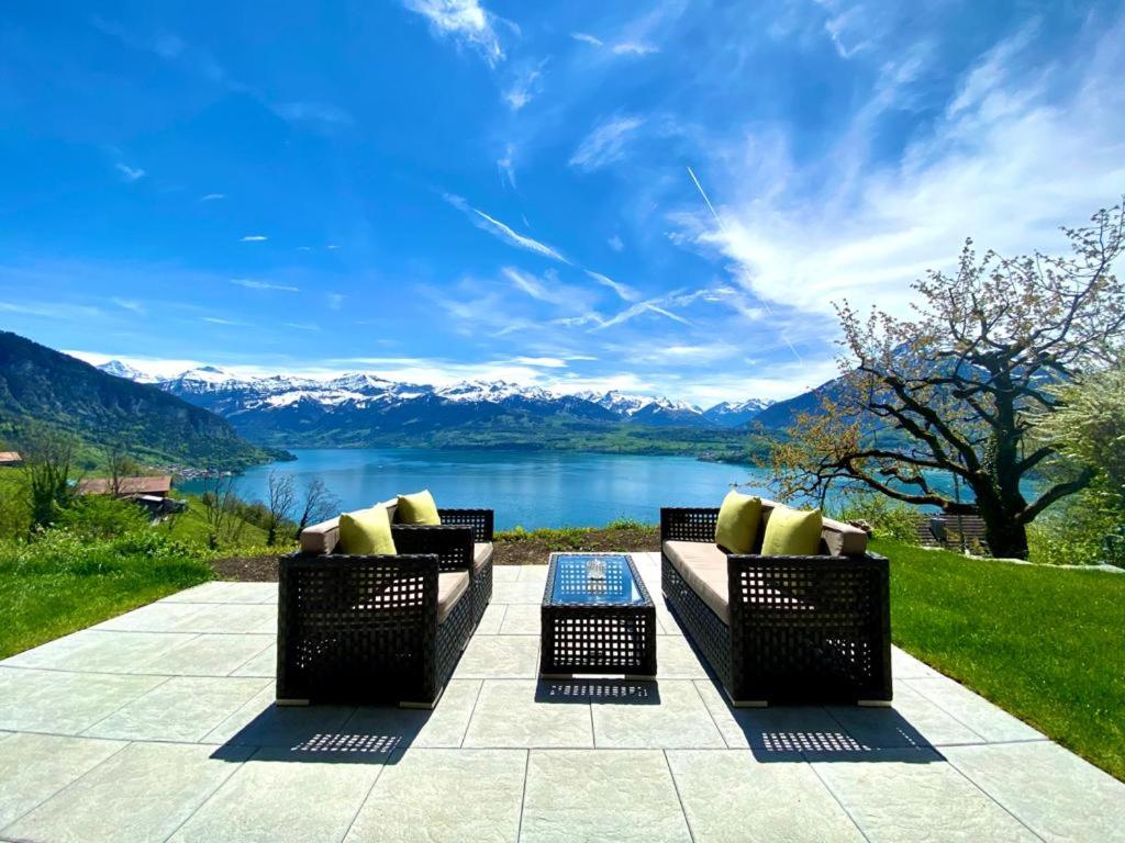 a patio with a view of a lake and mountains at Panorama Boutique Apartment with Air Condition, SPA entry in Solbadhotel in Sigriswil