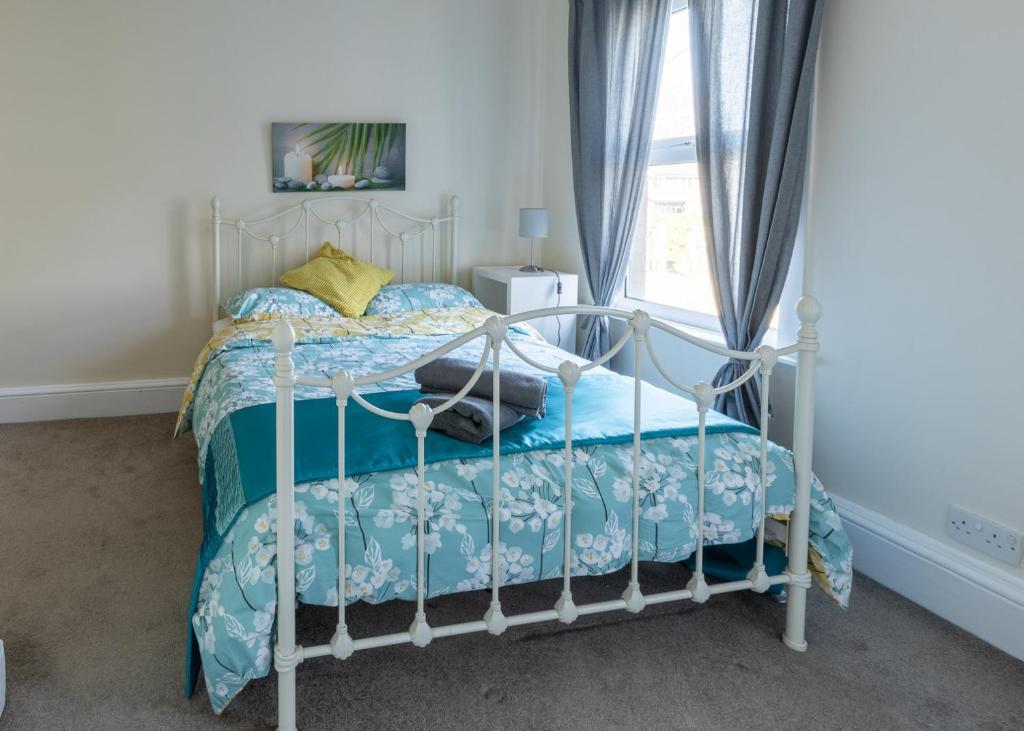 a bedroom with a white bed with a blue comforter at Parker House in Salisbury