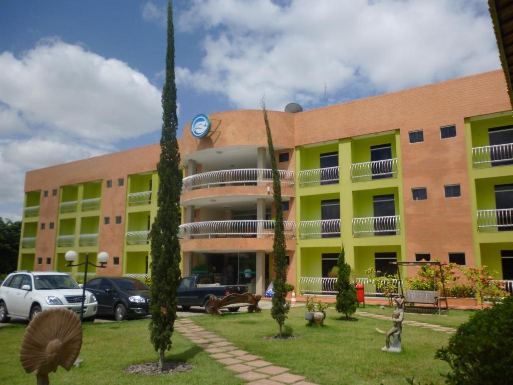 a building with cars parked in front of it at Hotel Absolar in Alagoinhas