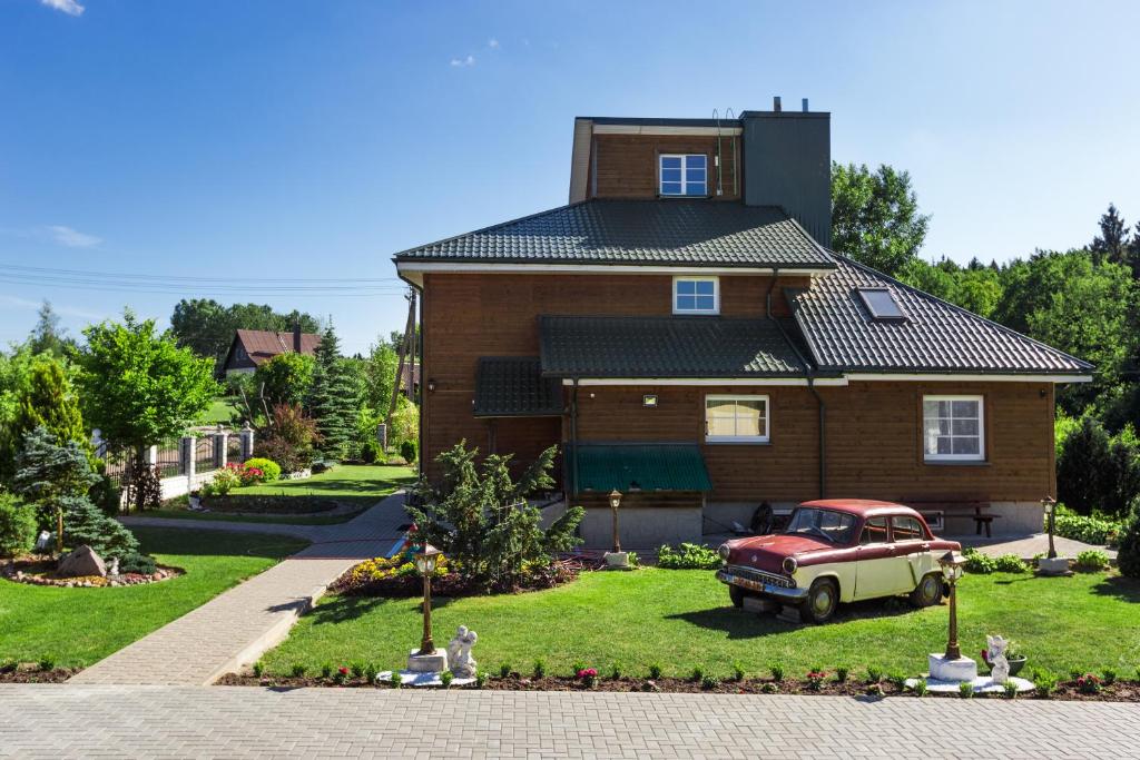 a house with a red truck in the front yard at Trakai Village apartments 
