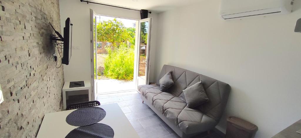 a living room with a couch and a sliding glass door at Chez Kaïs in Avignon