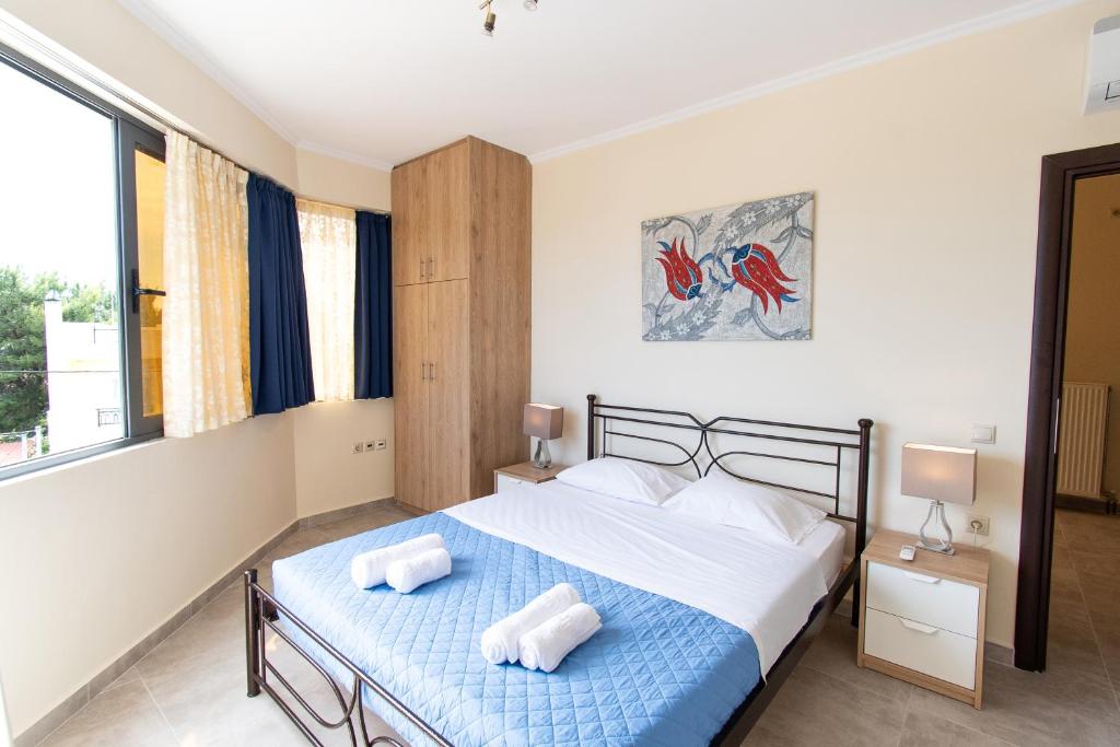 a bedroom with a bed with two towels on it at Apartments Efi in Artemida