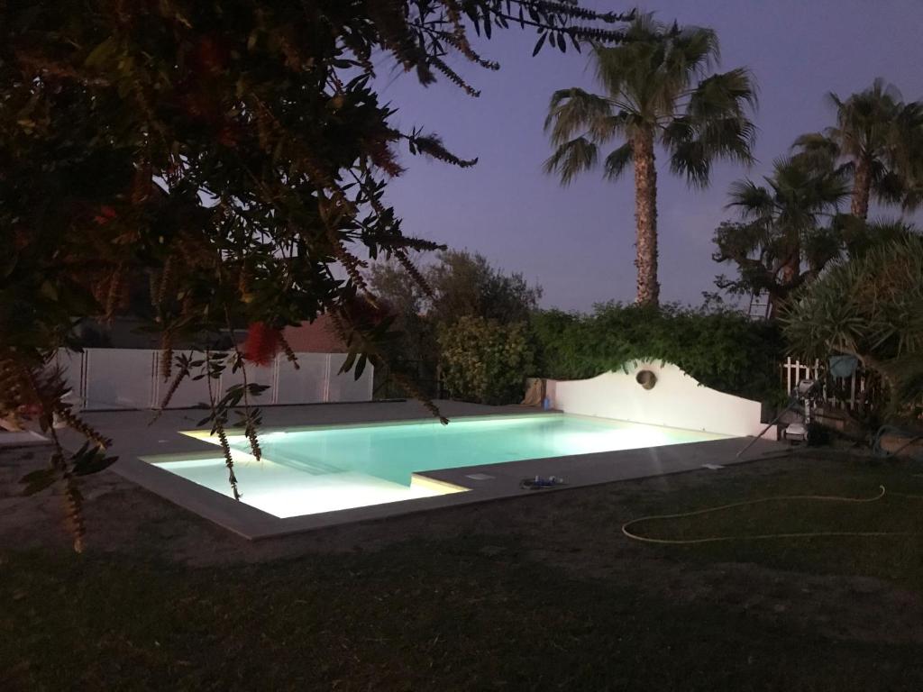 ein Schwimmbad mit Lichtern in einem Hof in der Nacht in der Unterkunft B&B Villa Di Giorgi in Cefalú