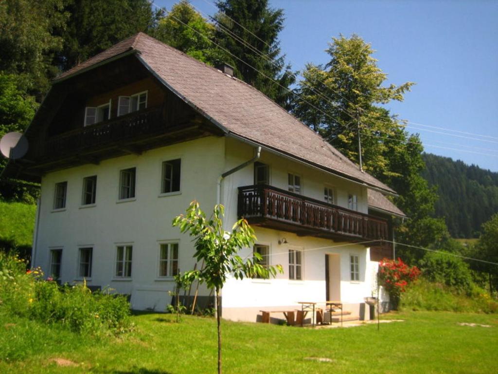 una grande casa bianca con tetto in legno di Ferienhaus Mesnerhaus Steuerberg a Feldkirchen in Kärnten