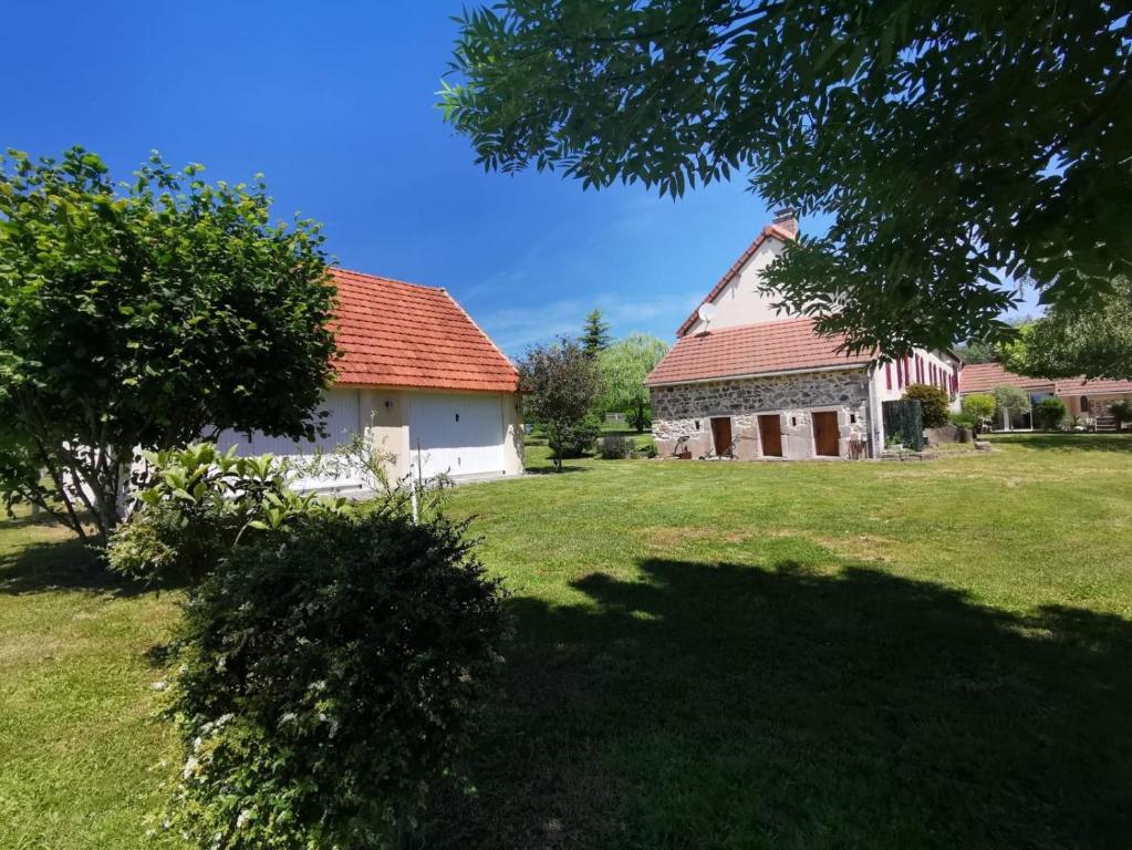 Luzy的住宿－Gites Luzy Morvan Bourgogne，一座有红色屋顶和草地庭院的房子