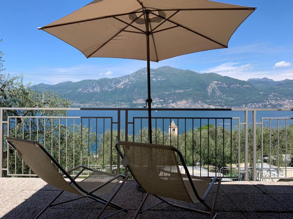 a chair with an umbrella sitting on a balcony at Camping Le Maior in Brenzone sul Garda