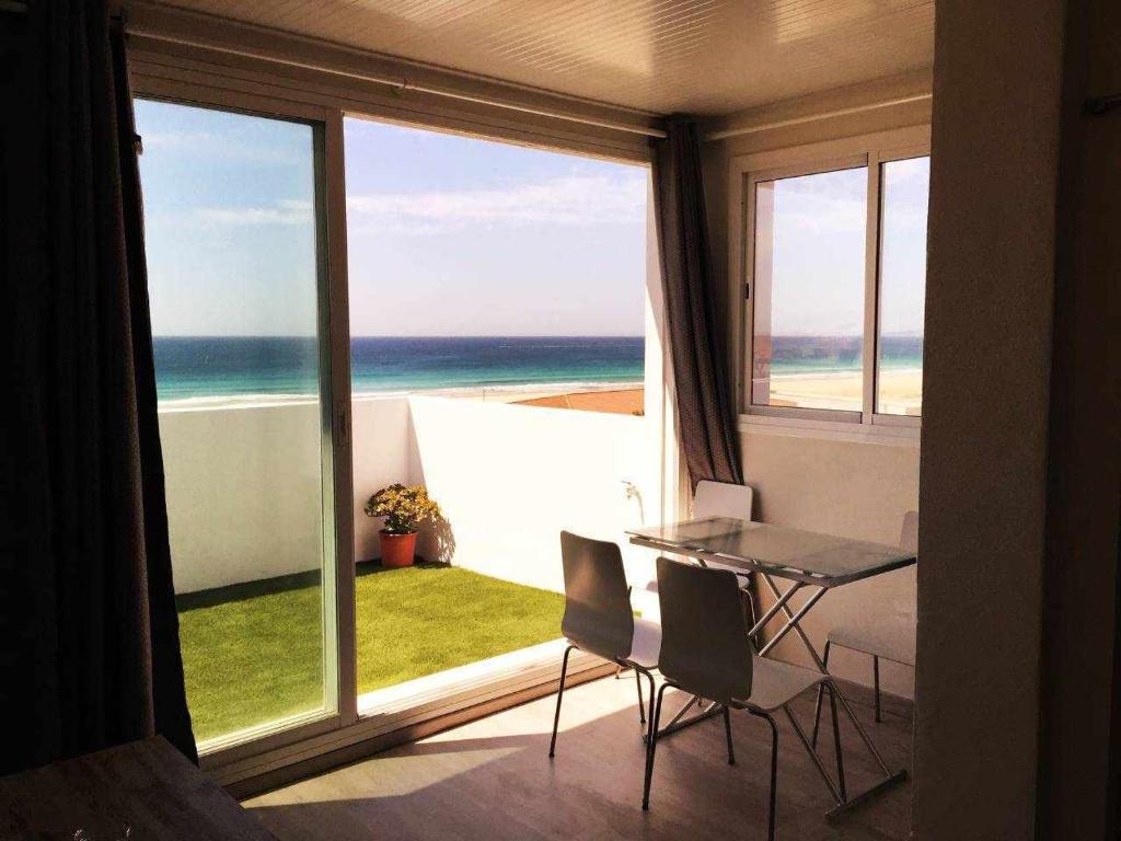 a room with a table and chairs and a view of the ocean at Ed Senses Apartamento Infinity in Tarifa