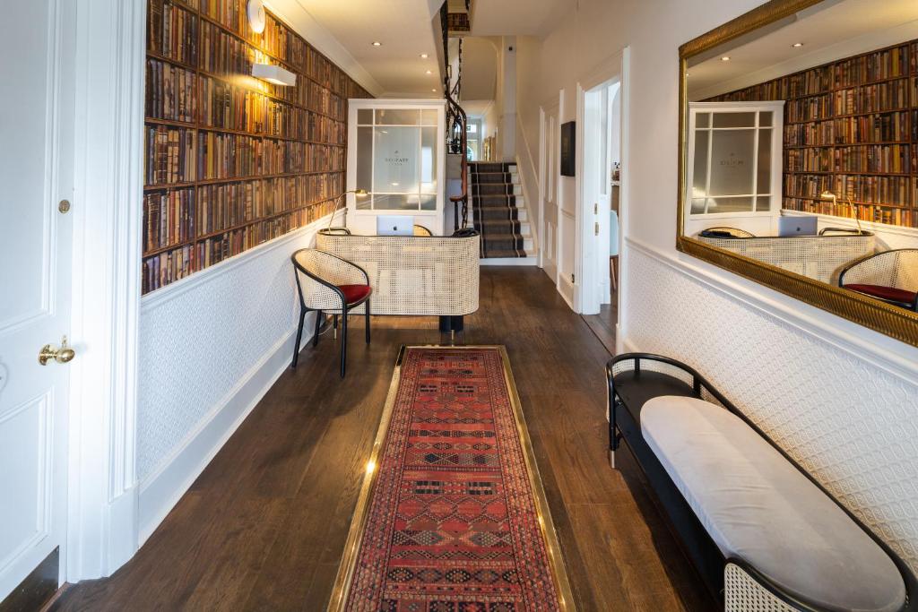 a hallway with a library with a table and chairs at The Roseate Villa Bath in Bath