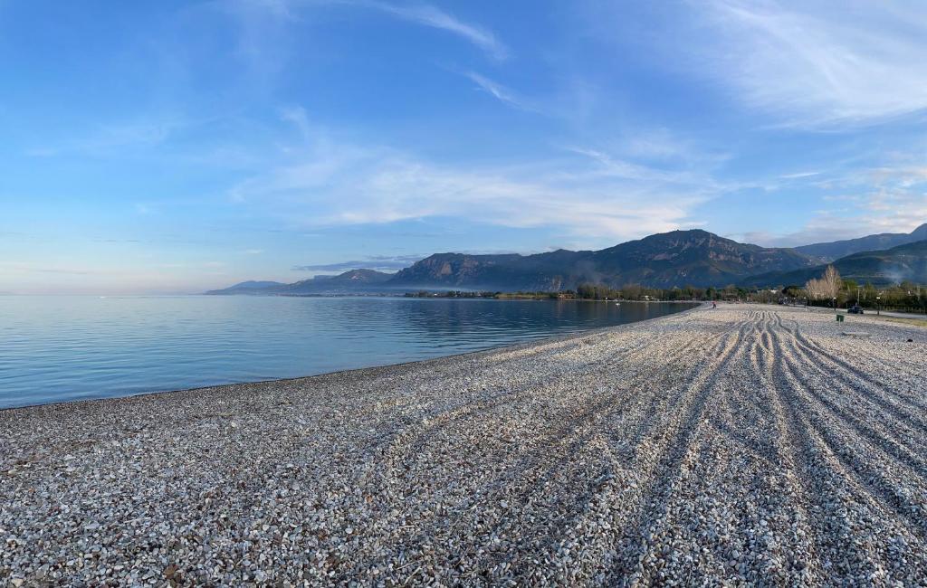 a beach with water and mountains in the background at Koulouras Holiday Apartments in Nikolaíika