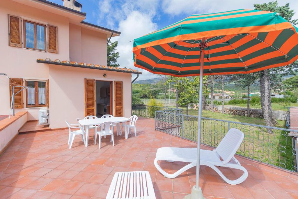 a patio with a table and chairs and an umbrella at HelloElba Appartamento Azzurro in Marina di Campo