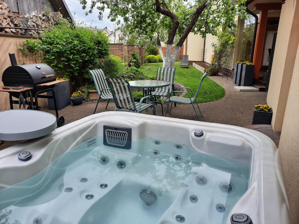 a hot tub in a backyard with a table and chairs at Helsinkis in Anykščiai