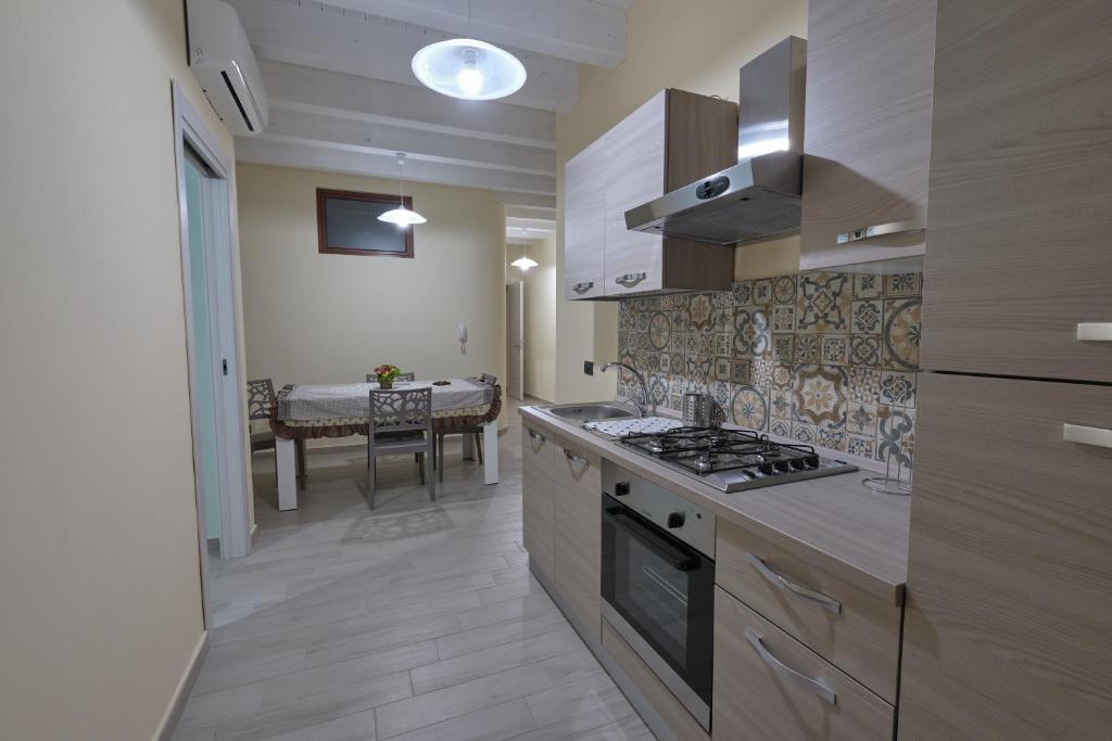a kitchen with a stove top oven next to a table at La rosa dei venti, apartment 3 in Porto Empedocle