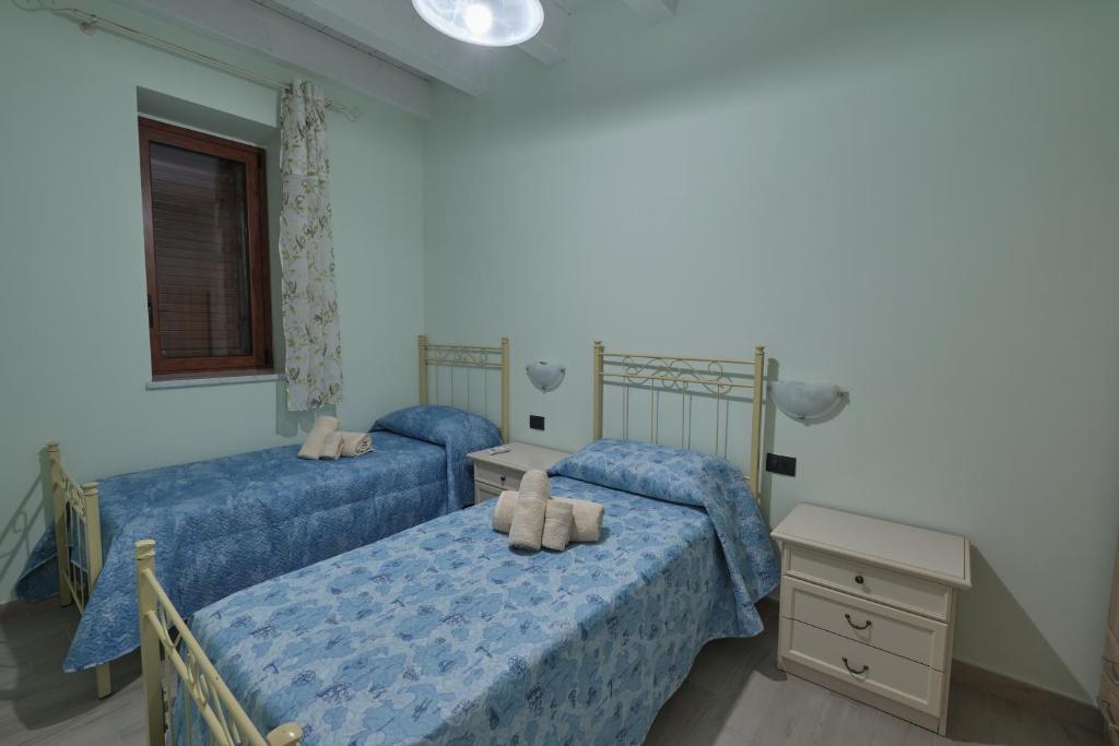 2 łóżka pojedyncze w sypialni z niebieską pościelą w obiekcie La rosa dei venti, apartment 3 w mieście Porto Empedocle