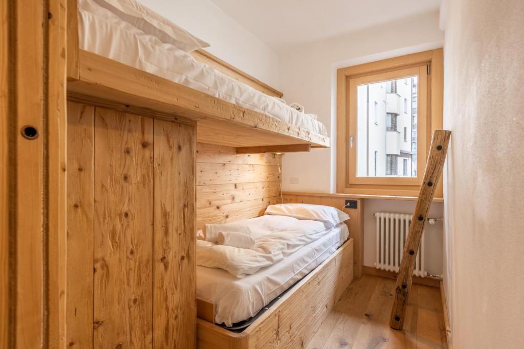 pokój z dwoma łóżkami piętrowymi i oknem w obiekcie Casa Olimpia w mieście Cortina dʼAmpezzo