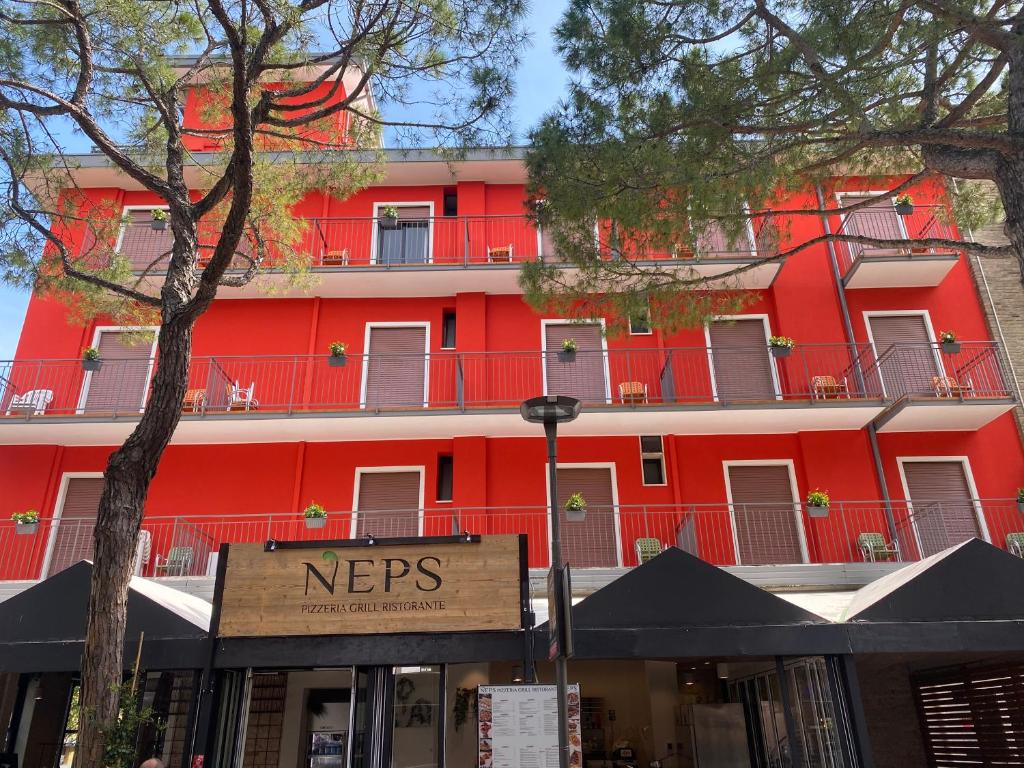 リド・ディ・イエゾロにあるHotel Nepsの目の前に看板が立つ赤い建物