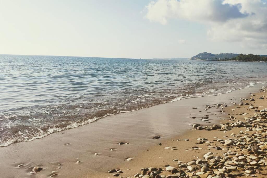a beach with rocks on the shore of the water at Modern Apartment, Few Meters from the Beach in Néa Koróni