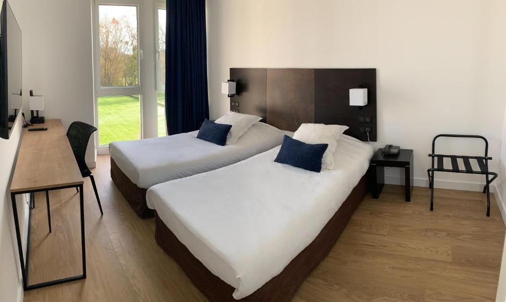 A bed or beds in a room at Hotel Abbaye du Golf de Lésigny