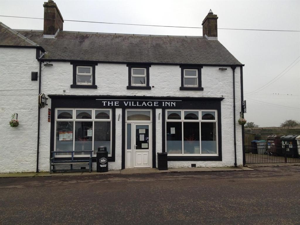 a white building with the village inn on the street at The Village Inn in Kirtlebridge