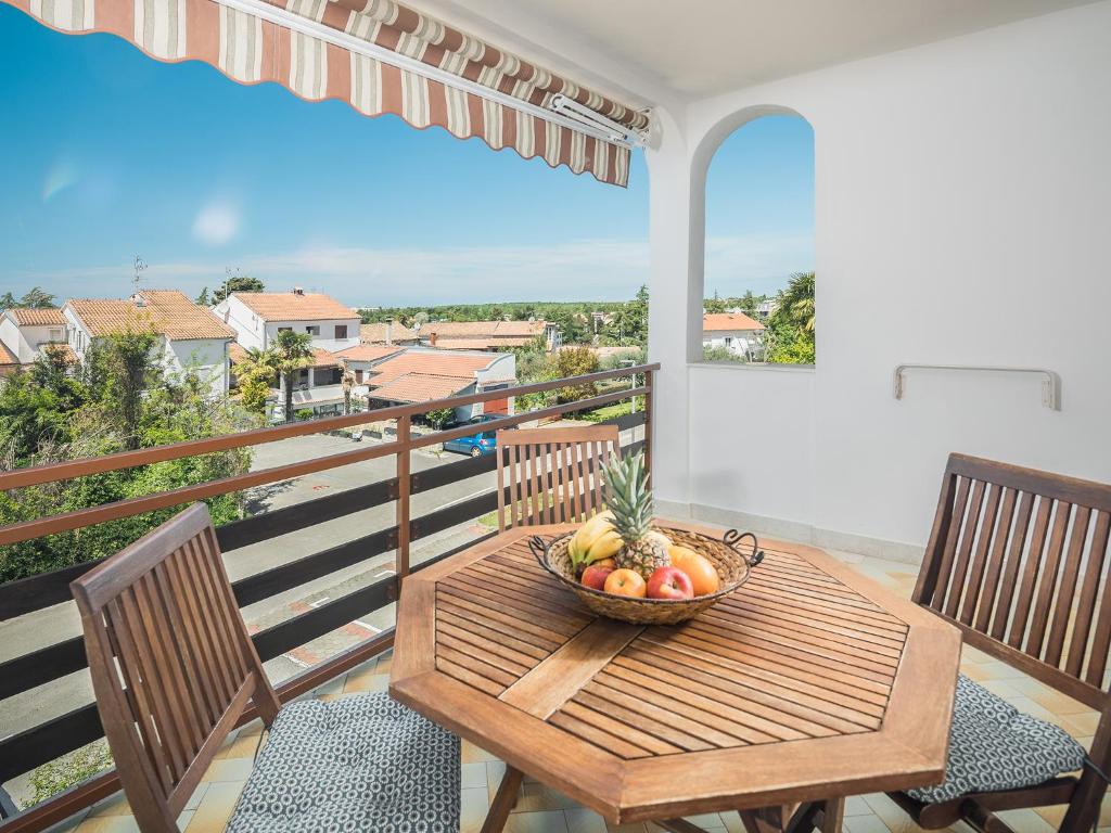 a bowl of fruit on a wooden table on a balcony at Apartments Špadići in Poreč