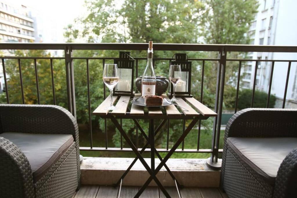 una mesa con 2 copas de vino en el balcón en George Apartment in Neuilly, en Neuilly-sur-Seine