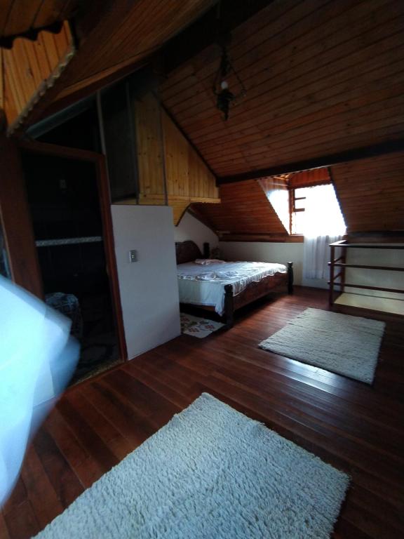 - une chambre avec un lit et un réfrigérateur dans l'établissement Chale além do horizonte, à Campos do Jordão