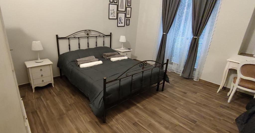 a bedroom with a black bed and a wooden floor at Casa Principe Taranto "Intero appartamento" in Taranto