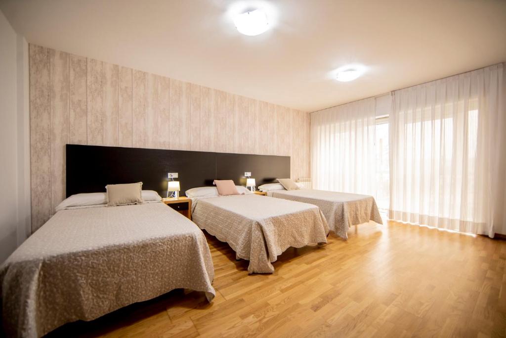 オ・ペドロウソにあるNoja rooms 1のベッドが2つと大きな窓がある寝室