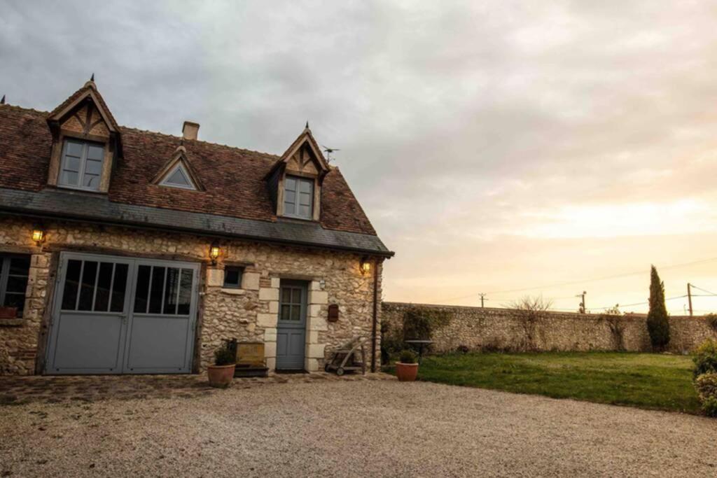 an old stone house with a garage at Longère Touraine Anjou in Hommes