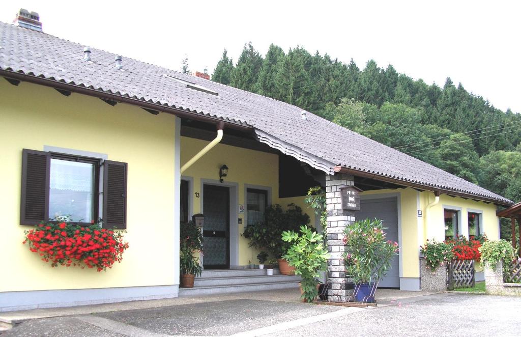 una pequeña casa amarilla con flores en la ventana en Gästehaus Lumesberger, en Grein