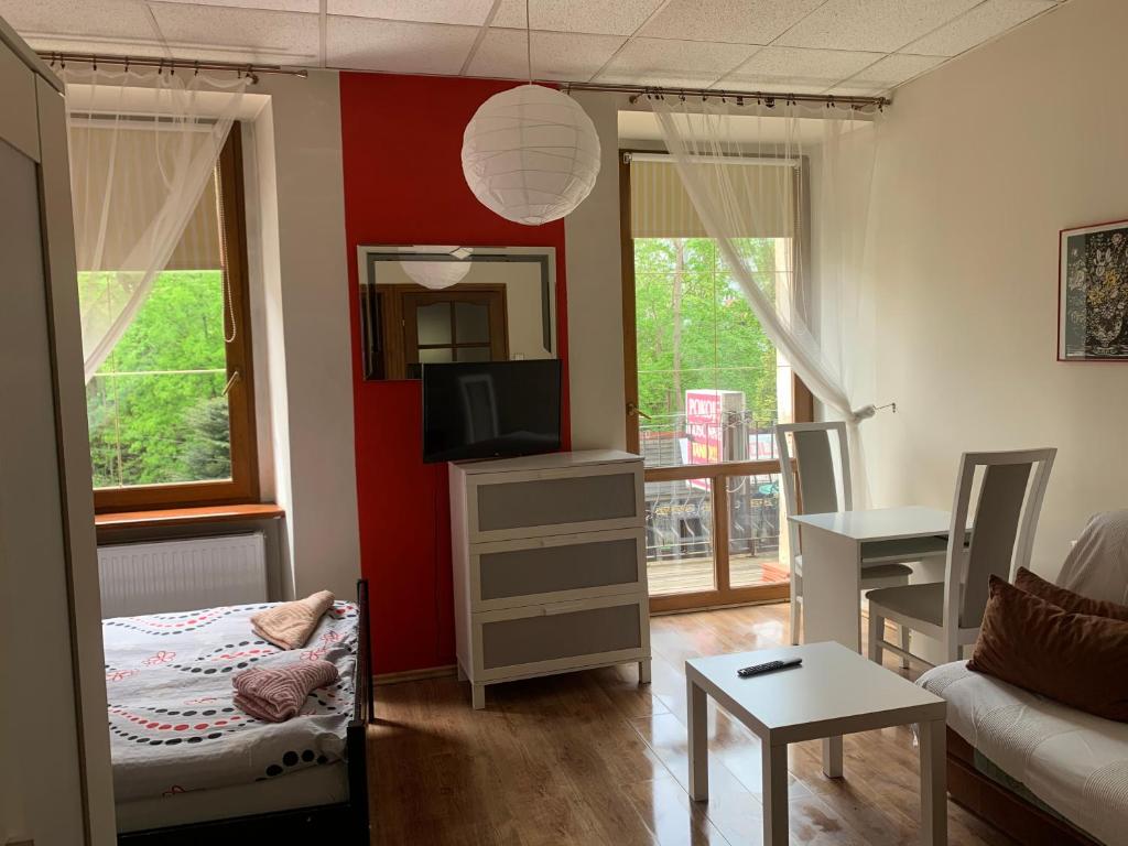 ein kleines Wohnzimmer mit einem Sofa und einem TV in der Unterkunft Apartamenty pokoje "MARIA" in Lądek-Zdrój