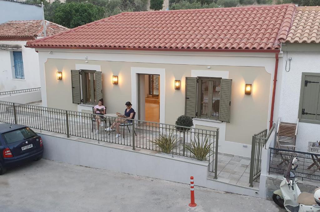 two people sitting on the balcony of a house at Villa Fouli in Tolo