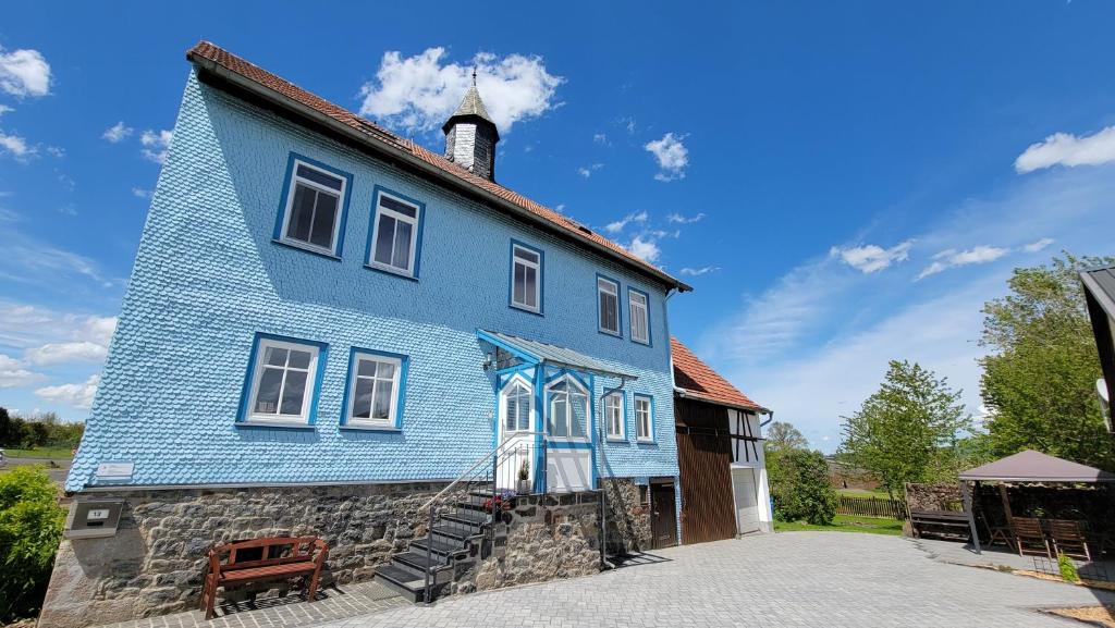 una casa azul con una torre encima en Schulhaus Wettges, en Birstein