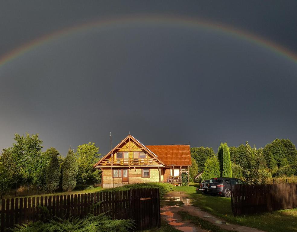un arco iris en el cielo sobre una casa en Białowieska Chata en Białowieża