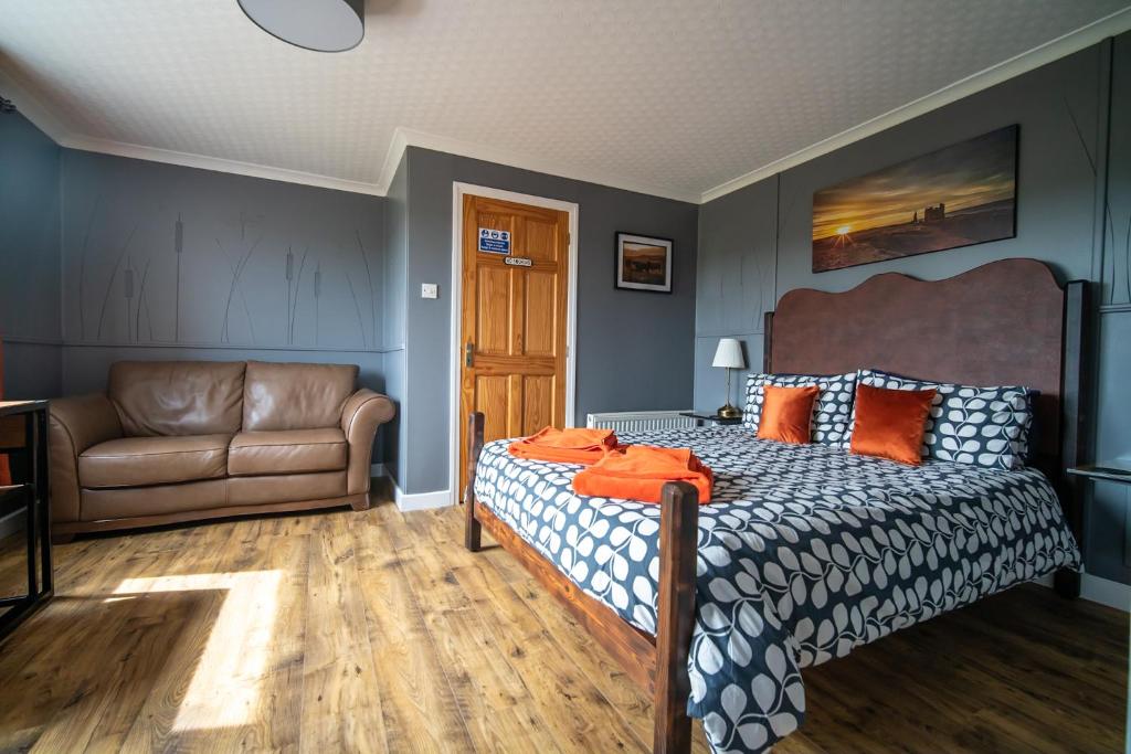 1 dormitorio con 1 cama y 1 sofá en Burnside Cottage, en Wick