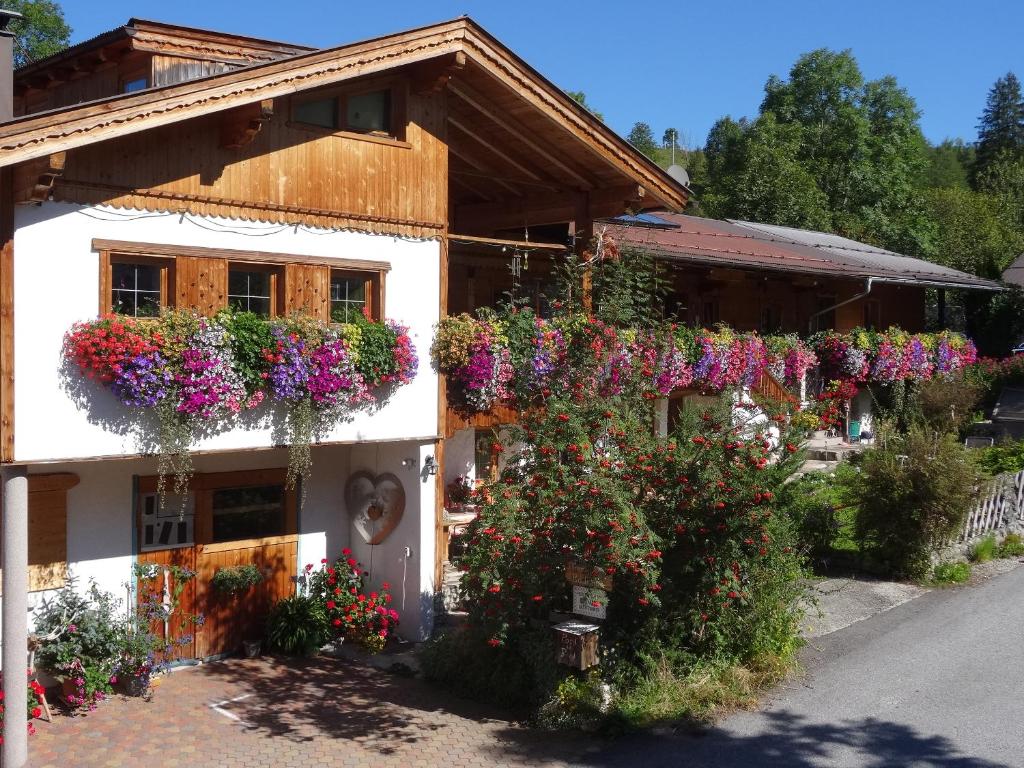 un edificio con flores a un lado. en Badhaus en Achenkirch