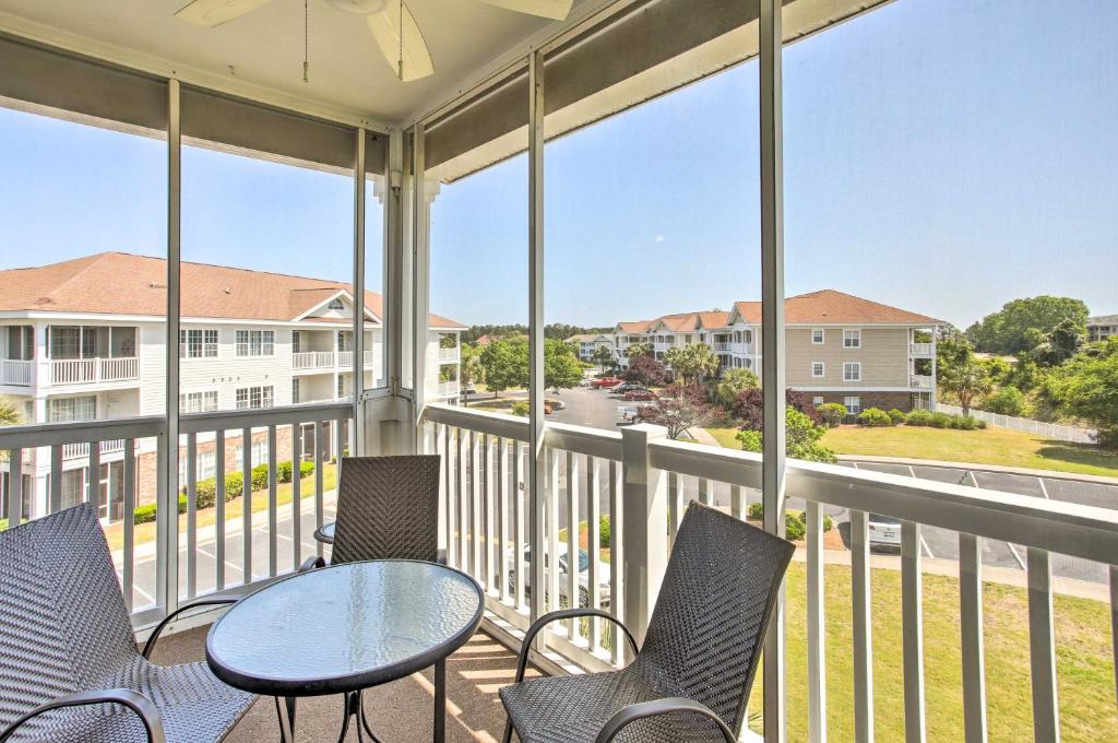 a balcony with chairs and a table and some windows at North Myrtle Beach Condo with Private Balcony! in Myrtle Beach