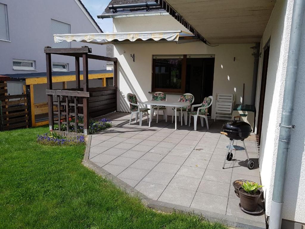 a patio with a table and chairs and a grill at Ferienwohnung Nscho Tschi in Pluwig
