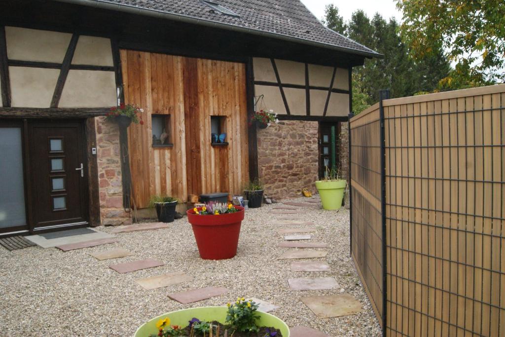 un jardin avec une maison clôturée et quelques plantes dans l'établissement Marlibelle, à Valff