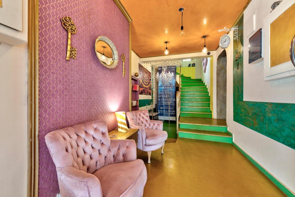 a room with two chairs and a pink wall at Boutique Florence in Ermoupoli