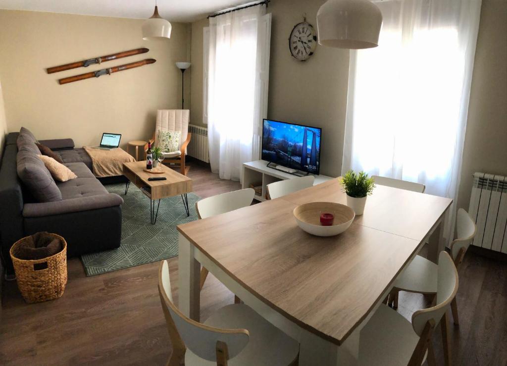 een woonkamer met een tafel en een bank bij Apartamento acogedor y familiar - WiFi+Chromecast in Puigcerdà