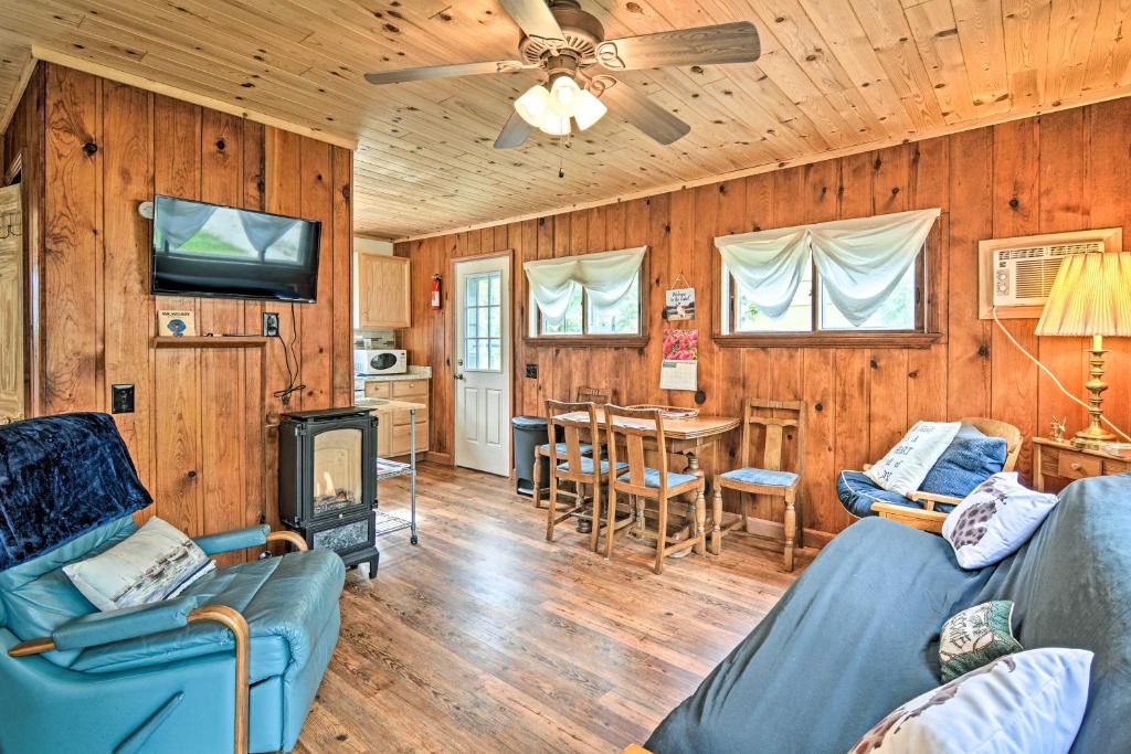 a living room with a couch and a tv and a table at Gateway to Boyne Mtn! 'Nestle by Lake' Cottage in Charlevoix