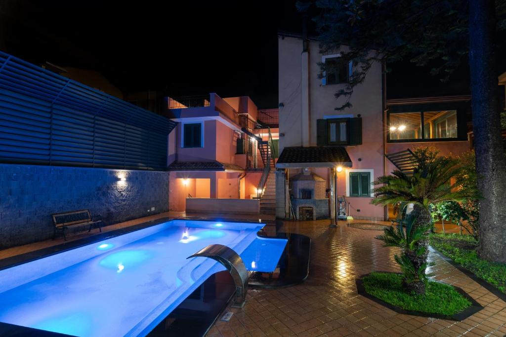 una piscina in un cortile posteriore di notte di ALHAMBRA - B&B - Guest House di Charme a Giarre