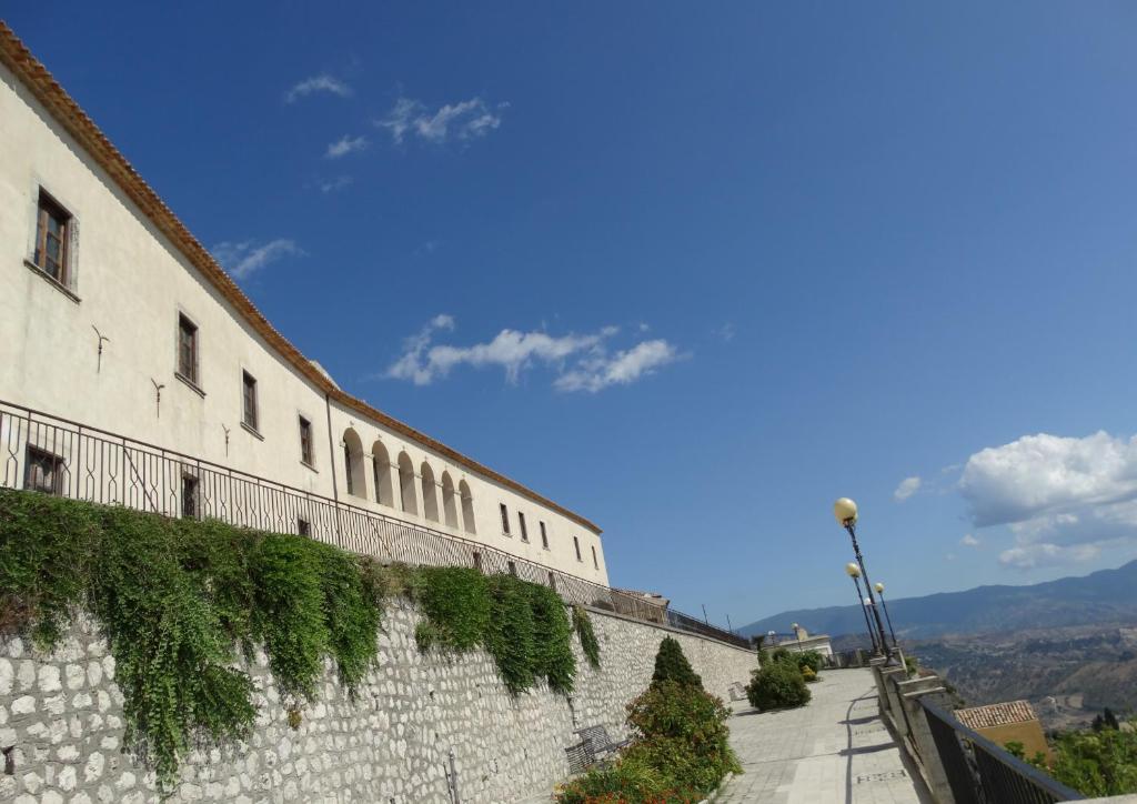 Un muro di pietra con l'edera che cresce sopra. di Albergo Palazzo Sant'Anna a Gerace