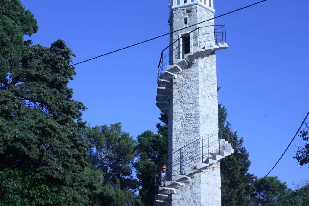 einen Leuchtturm am Ende einer Straße in der Unterkunft Rajska idila....Silba in Silba