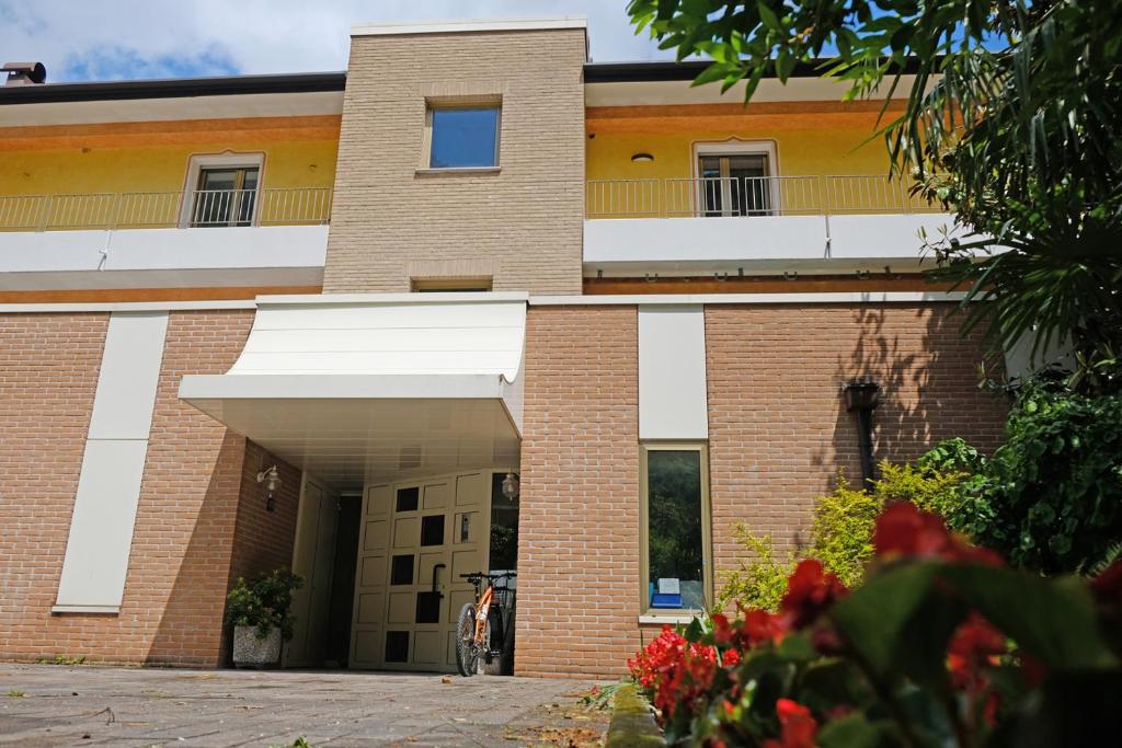 a brick building with a balcony on top of it at Appartamenti Alle 5 Torri in Mezzolombardo